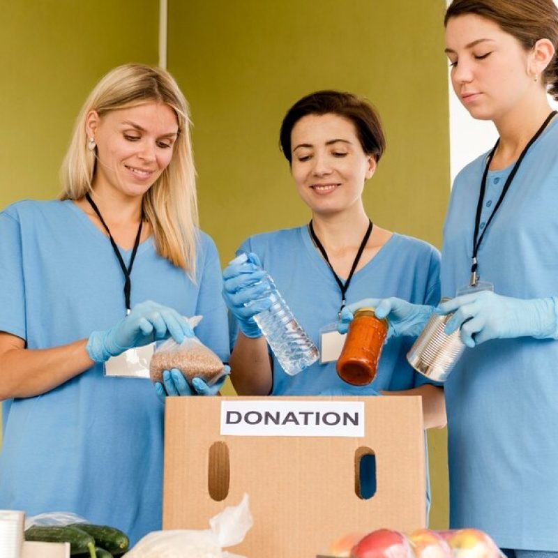 women-preparing-box-with-food-donation_23-2148613309